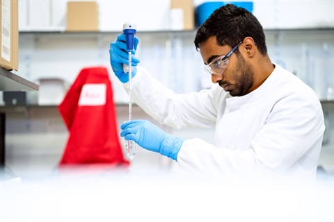 Man in white lab coat holding test tube